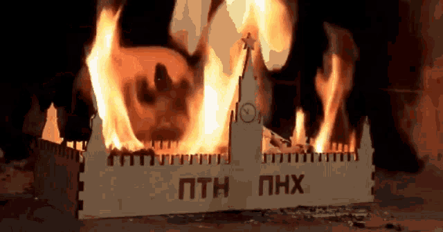a model of a building is burning in a fireplace with the word phx written on it