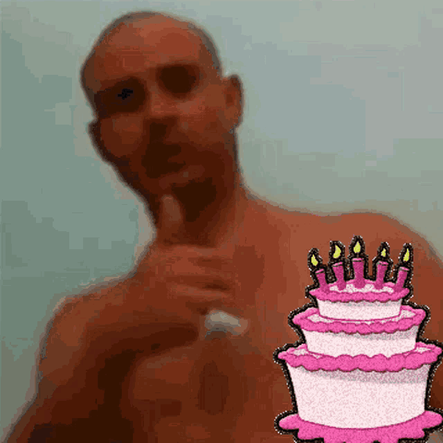 a man without a shirt is pointing at a birthday cake with pink frosting and candles