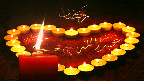 a heart made of candles with arabic writing and a red candle in the center