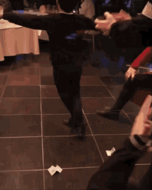 a person is walking on a tiled floor with a piece of paper on the floor