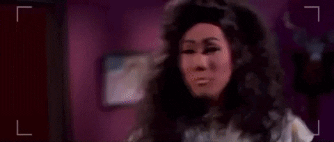 a woman in a wig is standing in front of a man in a wig .