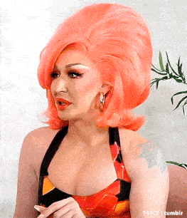 a woman with a tattoo on her arm has a very large orange wig