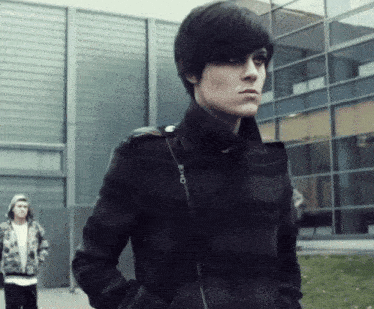 a woman wearing a black jacket with a zipper that says o on it