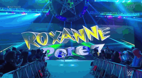 a crowd of people watching a wrestling match with the name roxanne pore on the screen