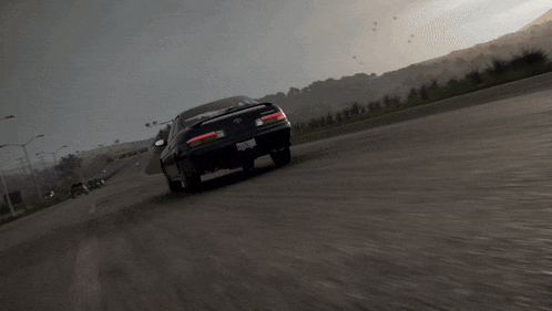 a car with a license plate that says ' acura ' on it is driving down a road