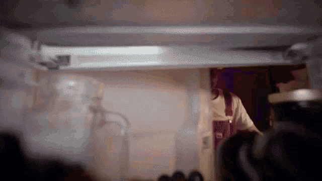 a person is standing inside of a refrigerator with a bottle of coca cola