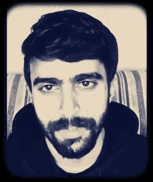 a man with a beard looks at the camera