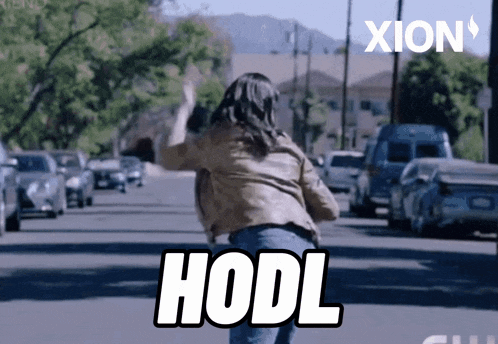 a woman is running down a street and the word hodl is on the bottom