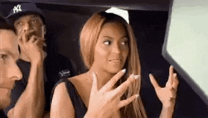 a woman is sitting in the back seat of a car with a man and a woman .