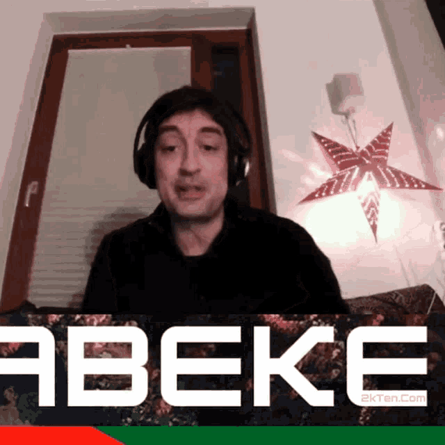 a man wearing headphones is behind a sign that says abeke