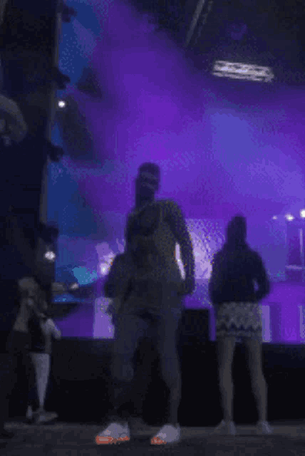 a blurry photo of people dancing in front of a large screen that says tnt