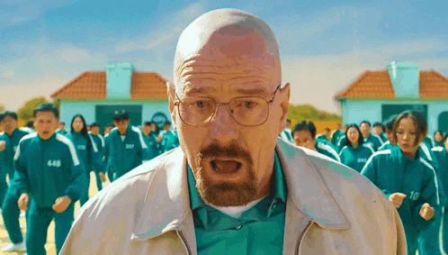 a bald man with glasses and a beard is standing in front of a group of people playing squid game .