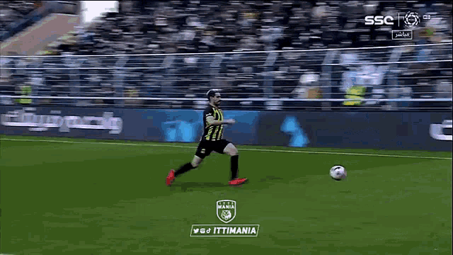 a soccer player is kneeling down to catch a ball in front of a sign that says ittimania
