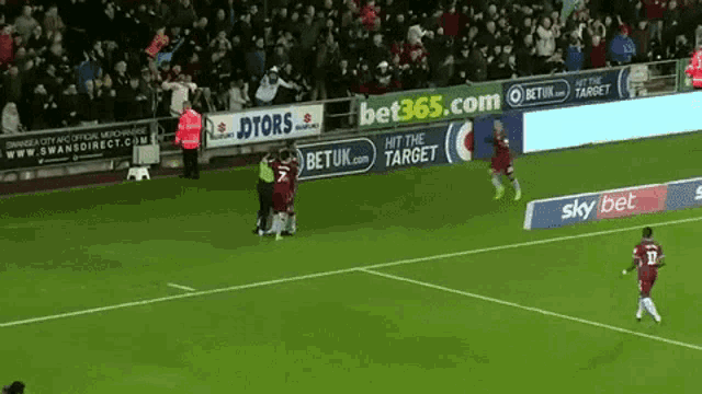 a soccer game is being played on a field with a sky bet banner