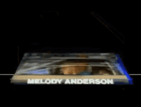 a picture of melody anderson sitting in a police car