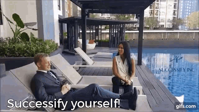 a man in a suit is laying on a lounge chair next to a woman who is sitting on a chair next to a pool