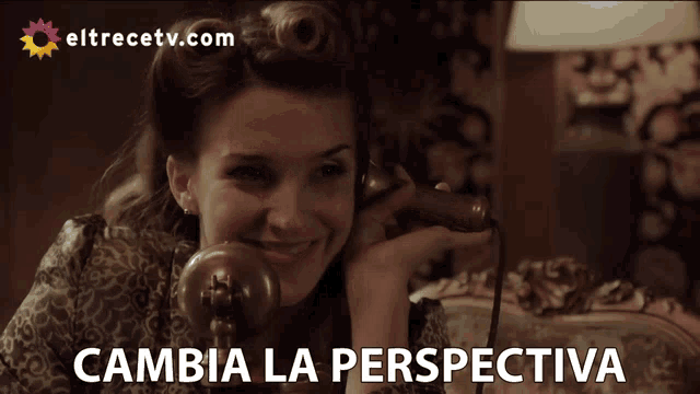 a woman is talking on a phone and the words cambia la perspectiva are below her