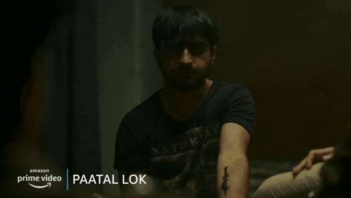 a man in a police uniform is talking to another man in a dark room with the name paatal lok on the bottom