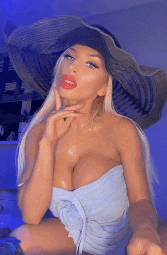 a woman wearing a large hat and a strapless dress