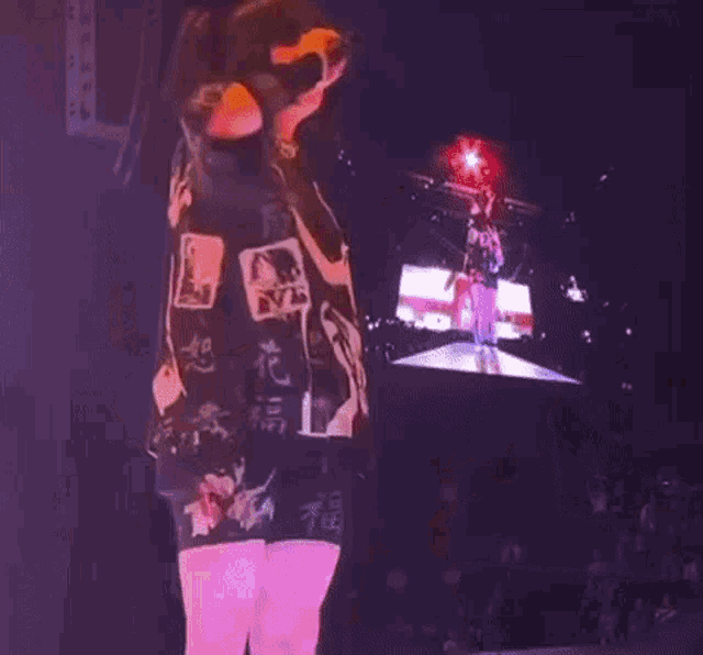 a woman is standing on a stage in front of a large screen .
