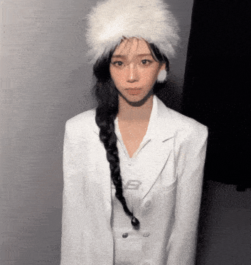 a woman wearing a braided ponytail and a white fur hat
