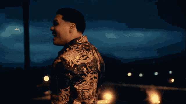 a man in a fancy shirt stands in front of a blue sky