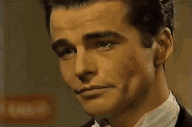 a close up of a man 's face with a red sign in the background that says no entry