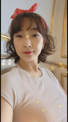 a woman wearing a white shirt and a red bow on her head