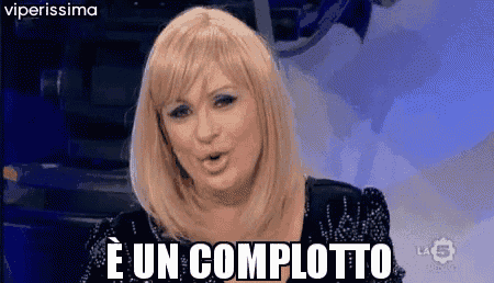 a woman with blonde hair says e un complotto on a blue background