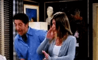 a man and a woman are standing next to each other in a living room .