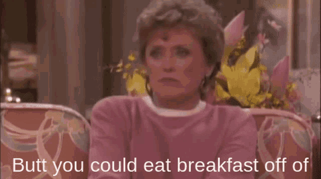 a woman in a pink shirt is sitting on a couch with the words butt you could eat breakfast off of below her