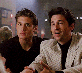 two men are sitting next to each other and one of them is wearing a plaid jacket