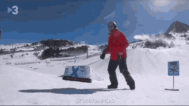 a man in a red jacket is skiing down a snow covered slope with a sign that says neu on it