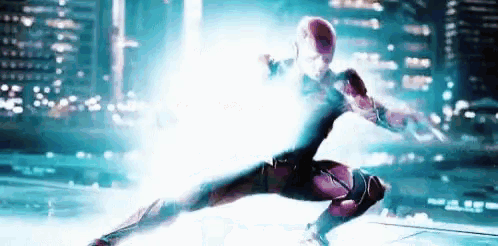 a person in a superhero costume is jumping in the air with a light coming out of his chest .