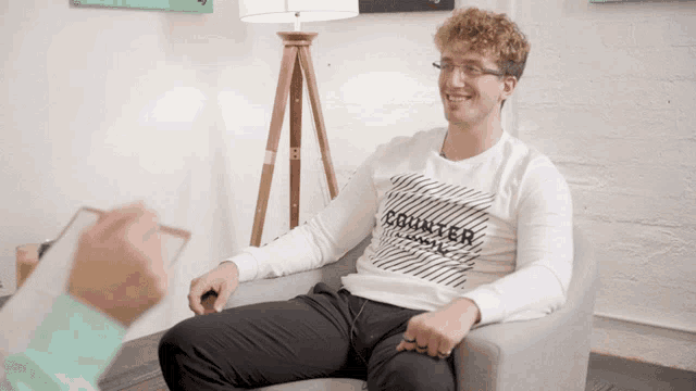 a man wearing a white sweater that says counter on it