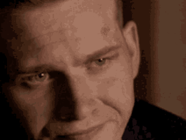 a close up of a man 's face with his eyes looking at the camera