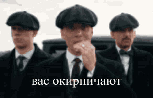 three men in suits and hats are standing next to each other with russian writing on the bottom right