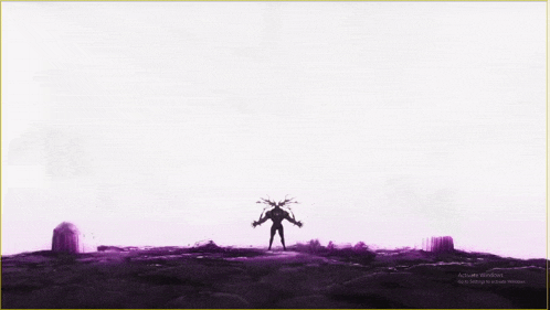 a silhouette of a person standing on top of a hill with a purple background .