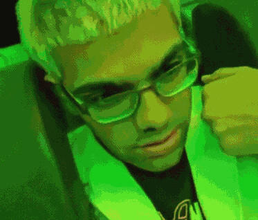 a pixelated image of a man wearing glasses and a green vest