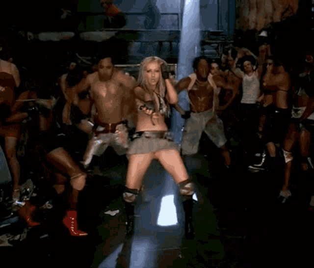 a woman in a short skirt is dancing with a group of people