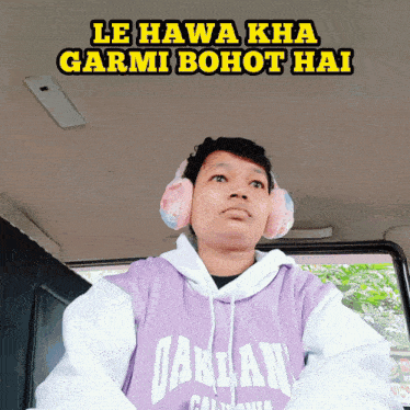 a man wearing ear muffs and a hoodie that says " oakland "
