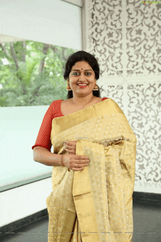 a woman wearing a yellow saree with a red blouse