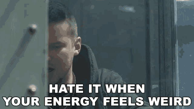 a man is peeking through a door with the words hate it when your energy feels weird