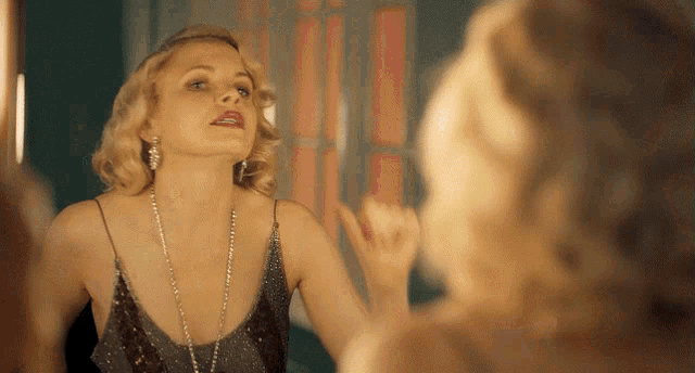 a woman looks at herself in the mirror