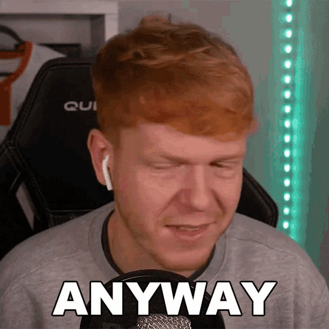 a man with red hair is sitting in front of a microphone with his eyes closed and the word anyway written on his face
