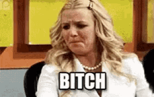 a woman is sitting in a chair and crying with the word bitch above her head .