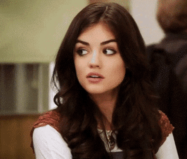 a woman with long brown hair is looking at the camera