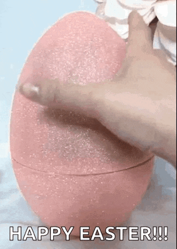 a person is holding a pink easter egg with the words `` happy easter !!! '' written on it .