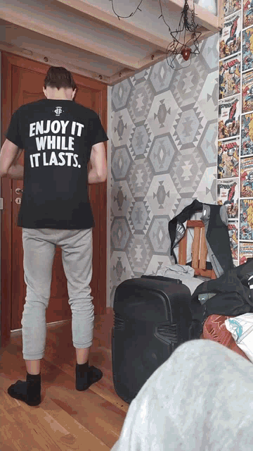 a man is wearing a black shirt that says enjoy it while it lasts
