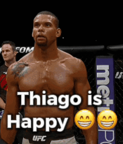 a shirtless ufc fighter stands in front of a sign that says thiago is happy